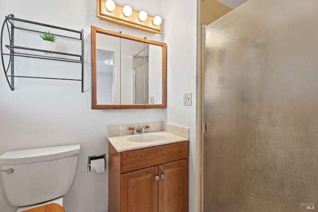 full bath featuring a stall shower, vanity, and toilet