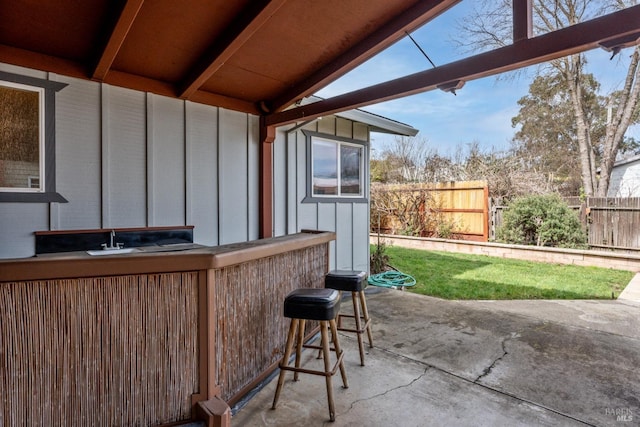 view of patio featuring fence and outdoor dry bar