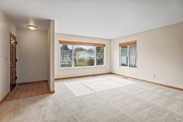 unfurnished room with visible vents, baseboards, and carpet flooring