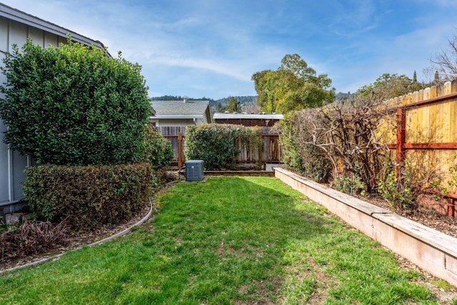 view of yard with central AC unit and a fenced backyard