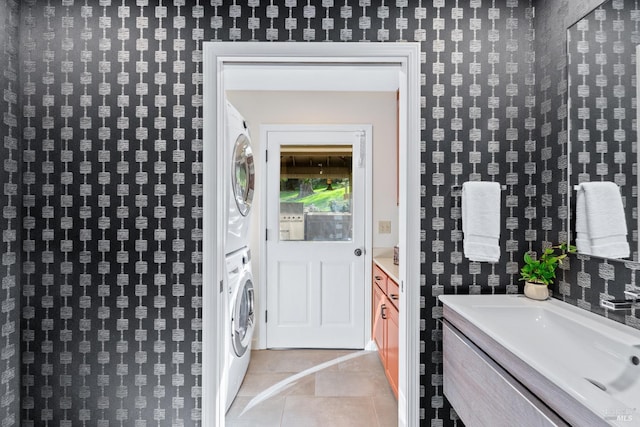 property entrance with stacked washer / dryer and a sink