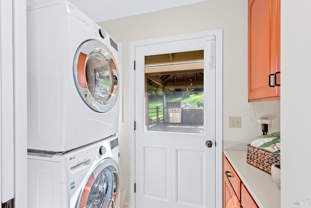 laundry area with stacked washing maching and dryer and cabinet space