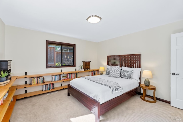 bedroom with light carpet and baseboards