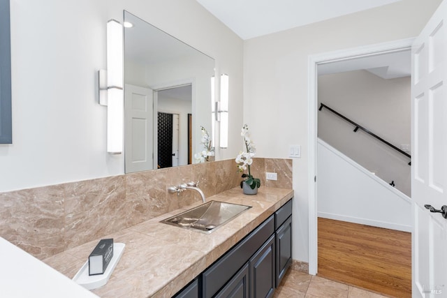 bathroom with tasteful backsplash, tile patterned flooring, vanity, and baseboards