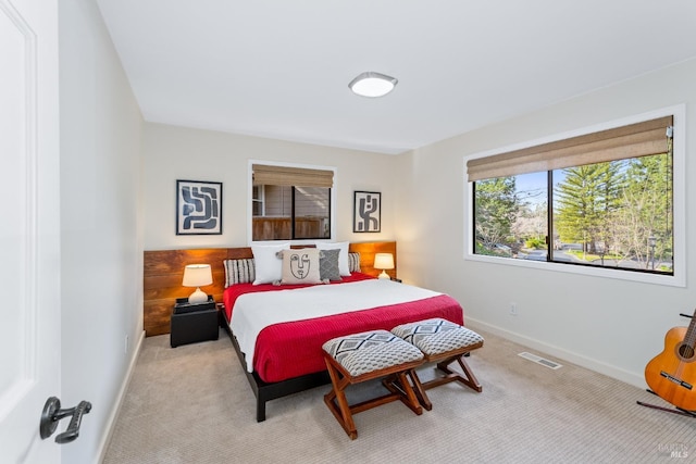 bedroom with baseboards, visible vents, and light colored carpet