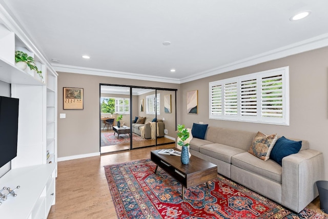 living area featuring baseboards, light wood finished floors, recessed lighting, and crown molding