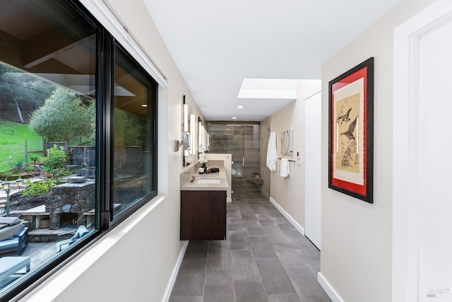 corridor with a healthy amount of sunlight, baseboards, and recessed lighting