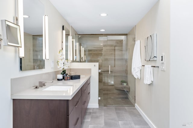 bathroom with recessed lighting, a sink, baseboards, a shower stall, and double vanity