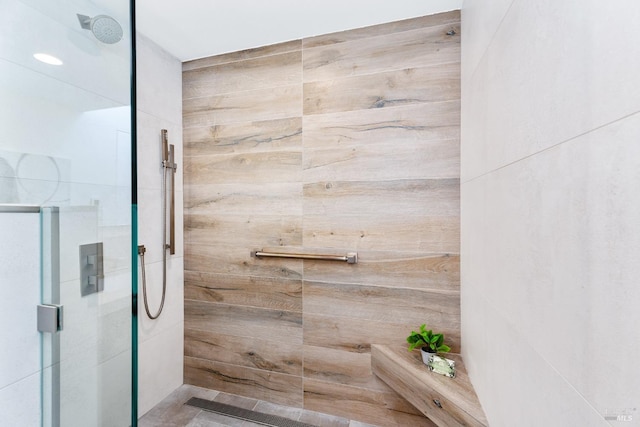 bathroom with wood walls and tiled shower