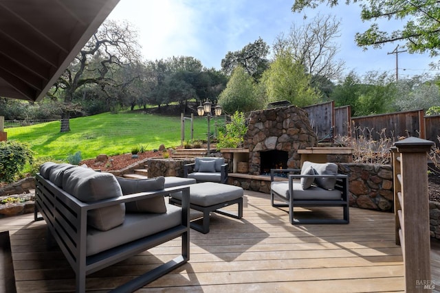 deck with an outdoor living space with a fireplace, fence, and a lawn