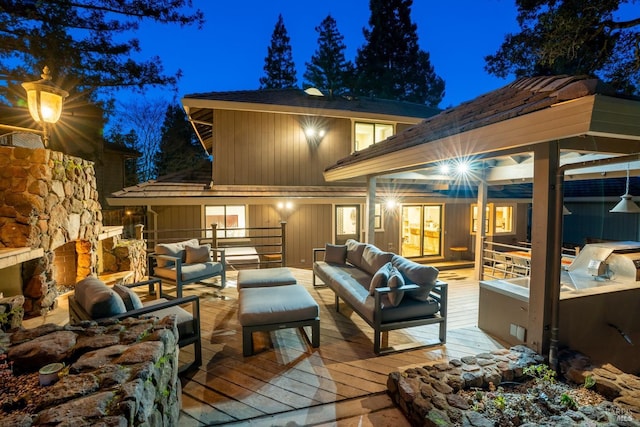 back of house at night with a deck and outdoor lounge area