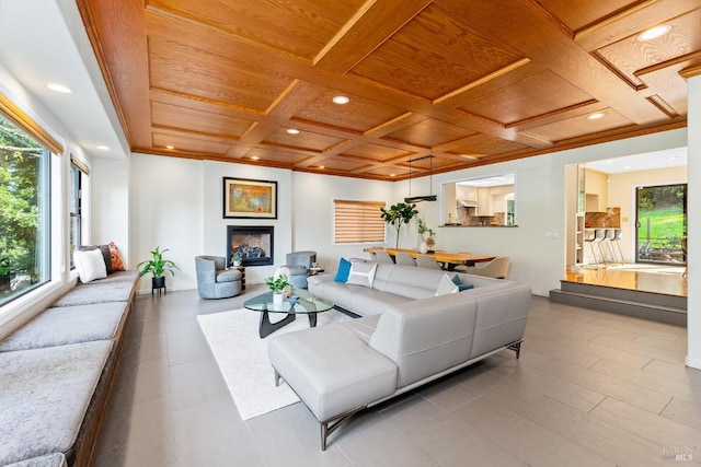 living area featuring plenty of natural light, wood ceiling, coffered ceiling, and a fireplace