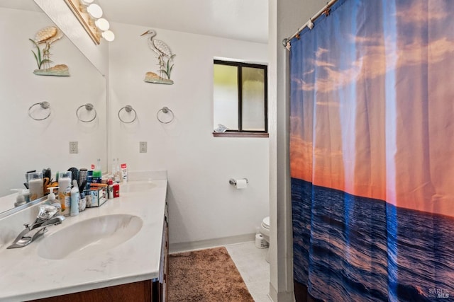 bathroom with tile patterned floors, a sink, toilet, and double vanity