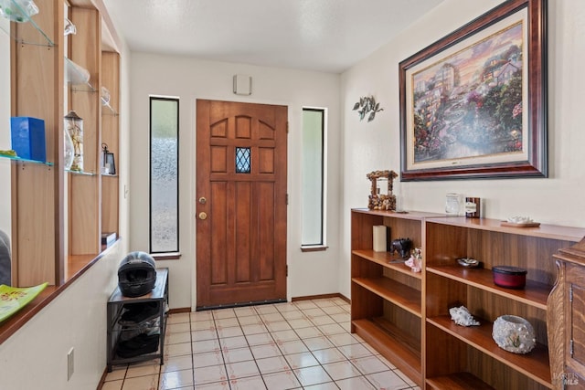 foyer entrance with baseboards and light tile patterned floors