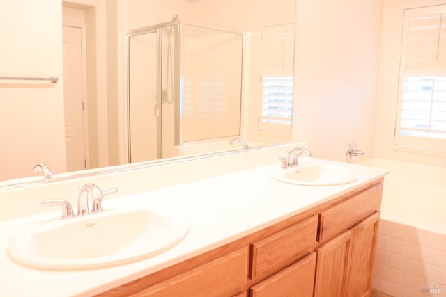 full bath with double vanity, a bath, a stall shower, and a sink