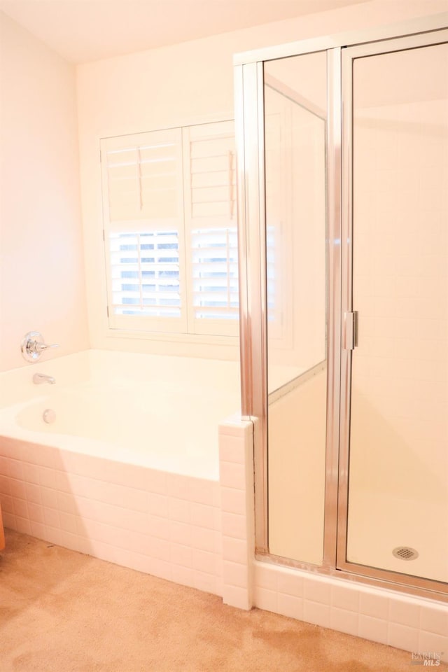 bathroom featuring a shower stall and a garden tub