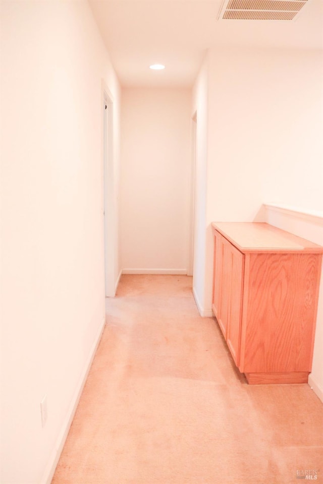 corridor with recessed lighting, visible vents, baseboards, and light colored carpet