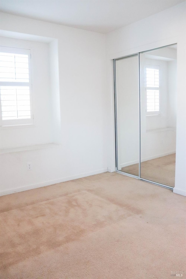 unfurnished bedroom featuring a closet, carpet flooring, and baseboards