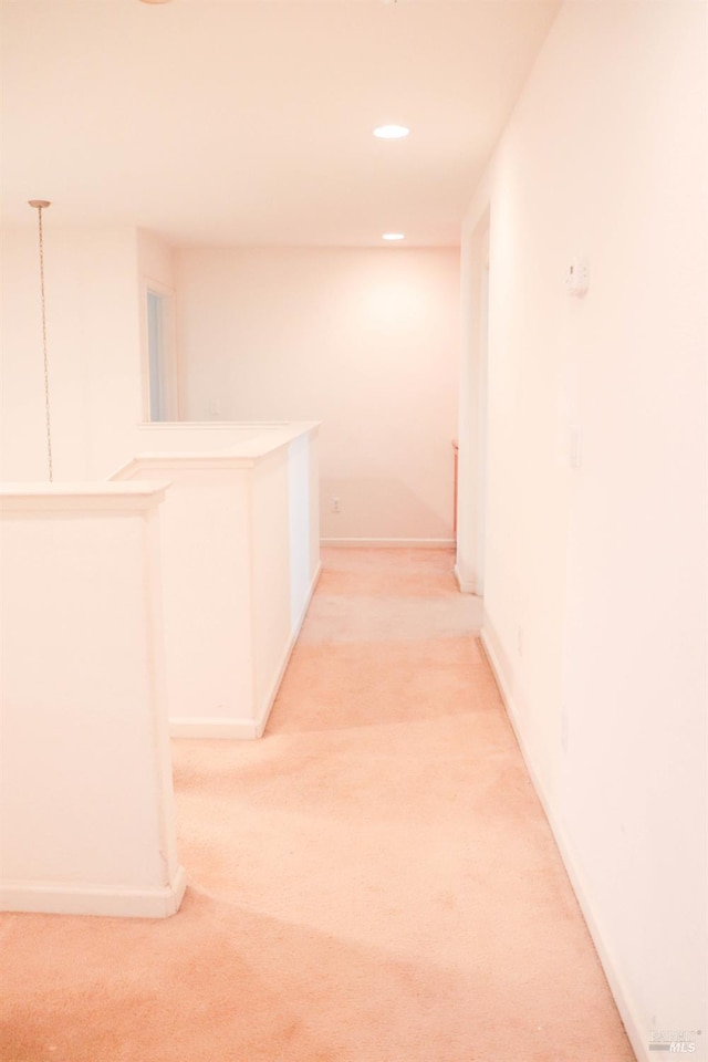 hallway with recessed lighting, an upstairs landing, baseboards, and light carpet