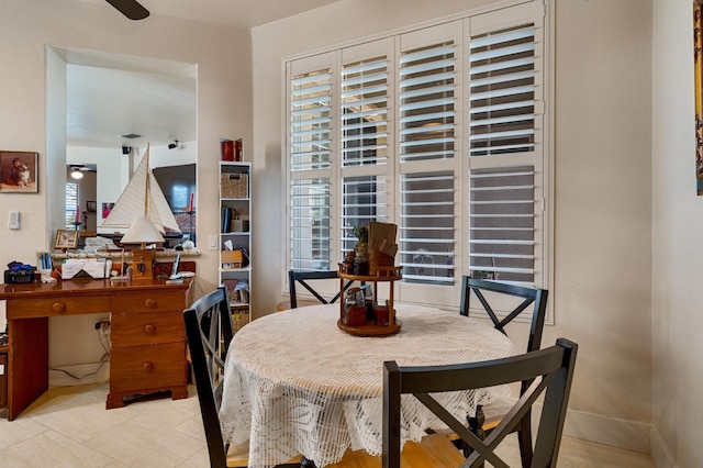 dining area featuring baseboards, a healthy amount of sunlight, and a ceiling fan