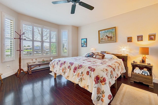 bedroom with multiple windows, ceiling fan, baseboards, and wood finished floors