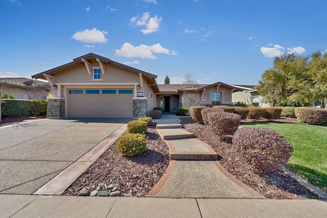 view of front of home featuring concrete driveway, an attached garage, and stone siding