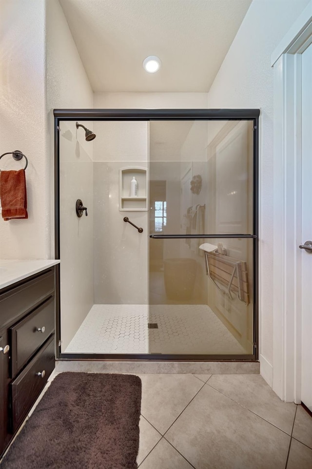 full bath with tile patterned floors, vanity, and a shower stall