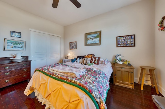 bedroom with a closet, baseboards, a ceiling fan, and dark wood-style flooring