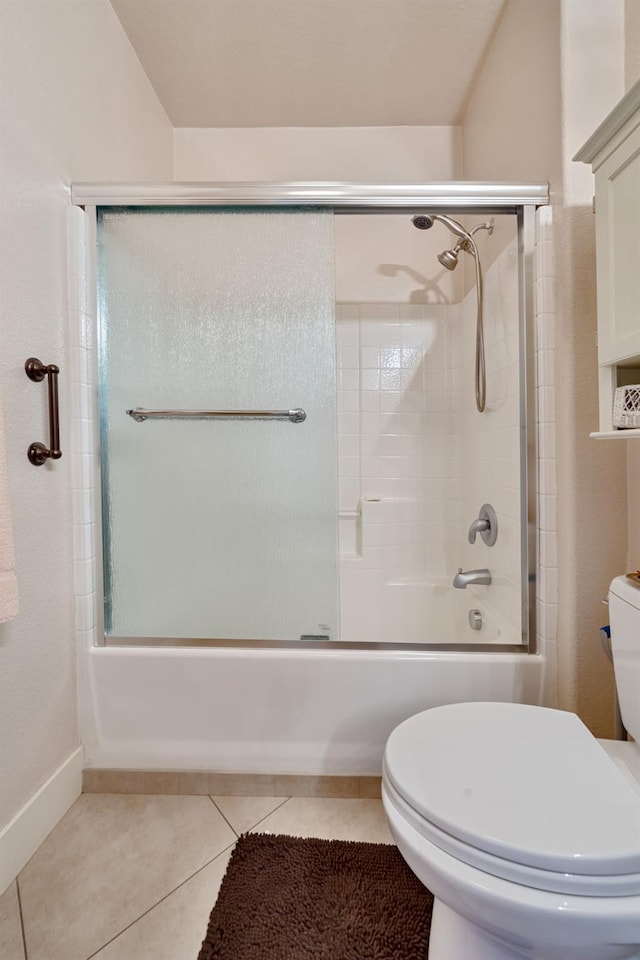 full bath featuring tile patterned floors, toilet, and bath / shower combo with glass door