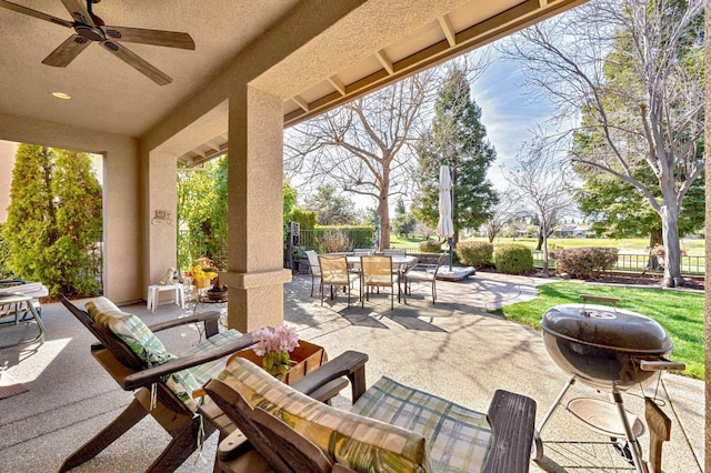 view of patio featuring outdoor dining area, a ceiling fan, fence, and a grill