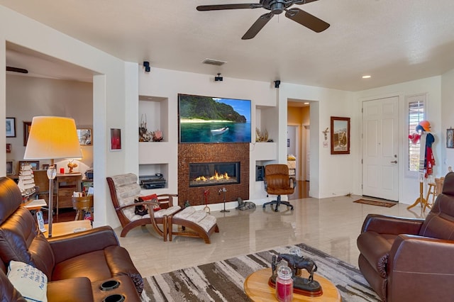 living room with visible vents, a tile fireplace, baseboards, and ceiling fan