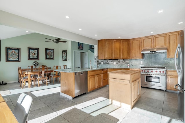 kitchen with stainless steel appliances, a center island, under cabinet range hood, and tasteful backsplash