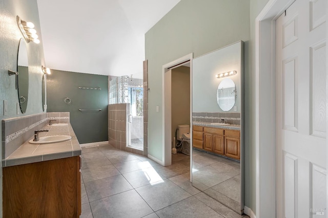 bathroom featuring tasteful backsplash, a sink, toilet, and double vanity