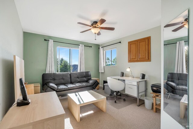 home office featuring light carpet and a ceiling fan