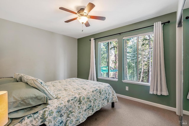 carpeted bedroom with baseboards and a ceiling fan