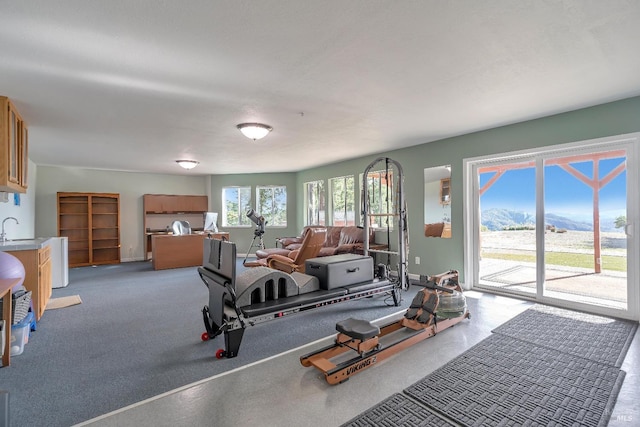 workout area featuring a sink, a mountain view, and baseboards