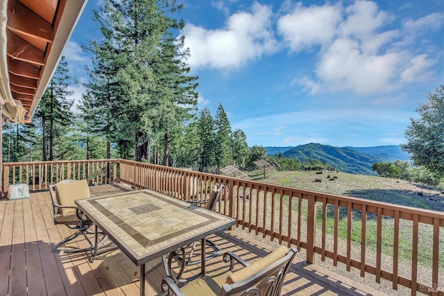 wooden deck featuring outdoor dining space and a mountain view