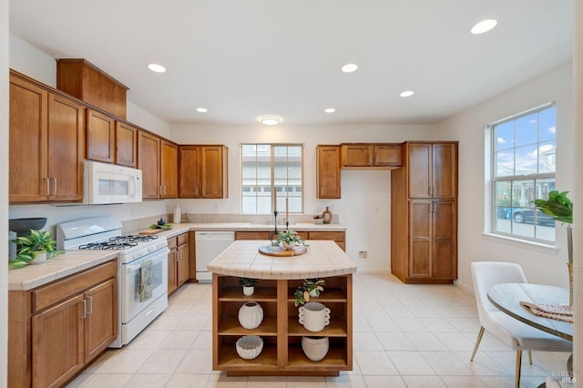 kitchen with white appliances, brown cabinets, tile counters, a center island, and open shelves