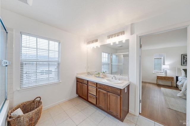 bathroom with connected bathroom, tile patterned floors, a sink, and double vanity