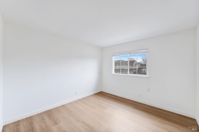 unfurnished room featuring light wood-style flooring and baseboards