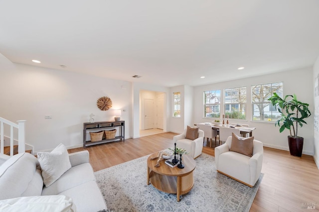 living room with light wood-style floors, baseboards, visible vents, and recessed lighting