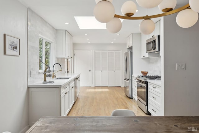 kitchen with appliances with stainless steel finishes, light countertops, and white cabinetry