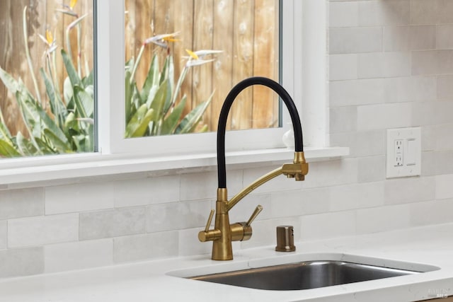 interior details with backsplash and a sink