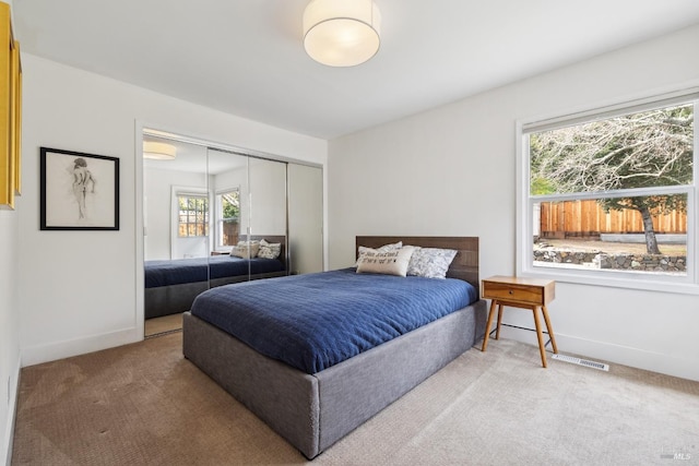 bedroom featuring visible vents, a closet, baseboards, and carpet flooring