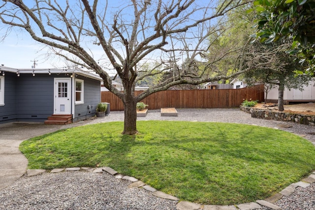 view of yard featuring entry steps and a fenced backyard