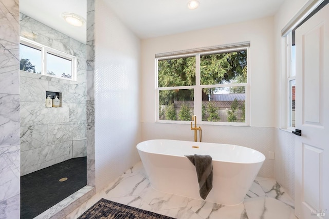 full bathroom featuring tile walls, a walk in shower, marble finish floor, and a freestanding bath