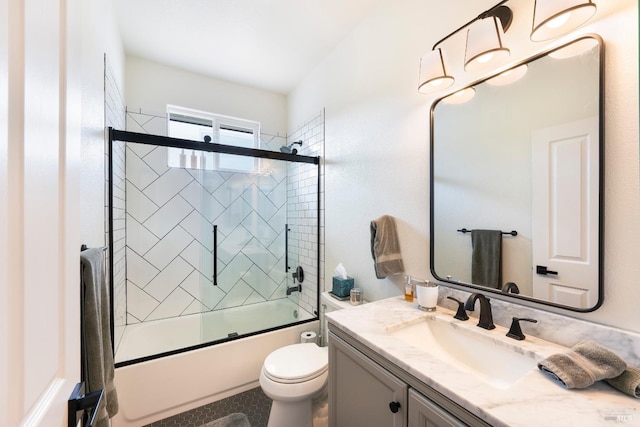 bathroom with vanity, toilet, and combined bath / shower with glass door