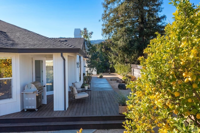 wooden terrace featuring a grill and fence