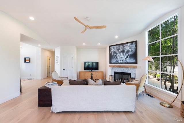 living room with recessed lighting, light wood-style floors, lofted ceiling, and plenty of natural light