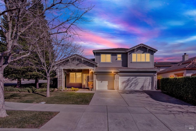 traditional-style home with an attached garage, driveway, and a tiled roof